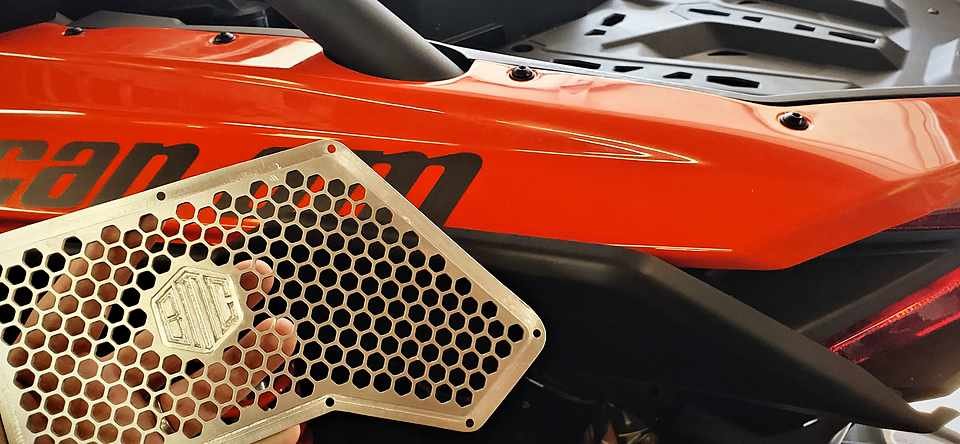 Close detail of the laser-cut honeycomb intake grille panel, edges still sharp off the cutter.