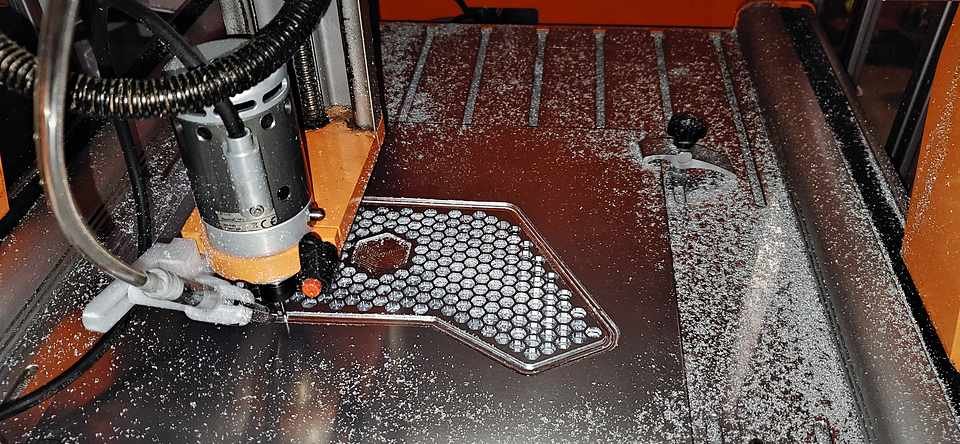Close-up of the CNC spindle mid-cut, aluminum chips curling off the tool.