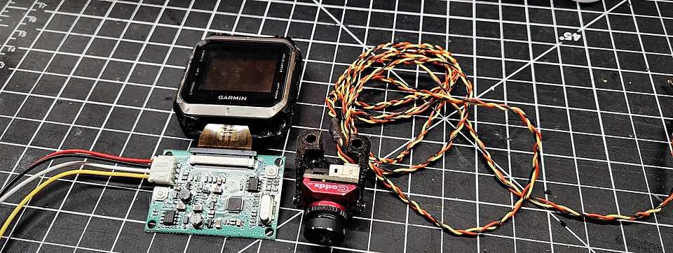 Flight controller board and sensor module laid out on a gridded cutting mat for wiring layout.